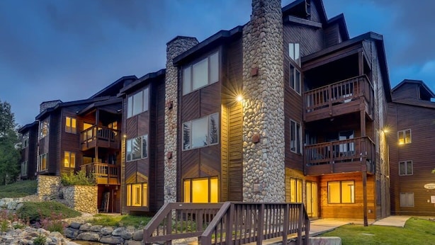 A multi-story building with balconies, stone accents, and a wooden deck. - Lift View Place | Steps to Lift | Walk to Main St! (Breckenridge)