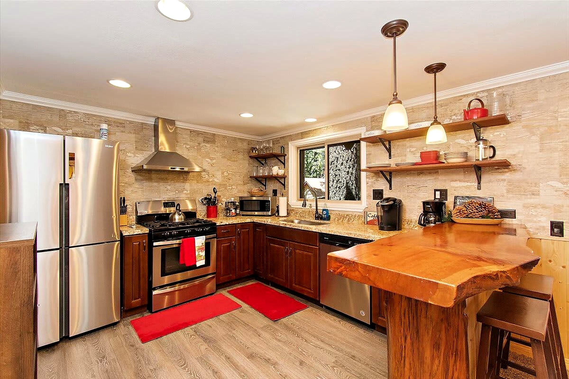 Remodeled kitchen with stainless appliances and live-edge wood bar