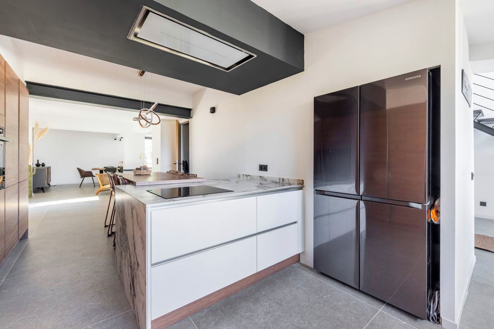 A modern kitchen with a large island, stainless steel appliances, and a minimalist design.