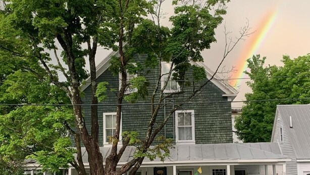 A two-story house with a porch, surrounded by trees. - Terrapin Hostel (Kingfield)