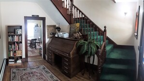 A staircase with a green carpet, a wooden desk with drawers, a bookshelf, and a framed picture on the wall. - Terrapin Hostel (Kingfield)