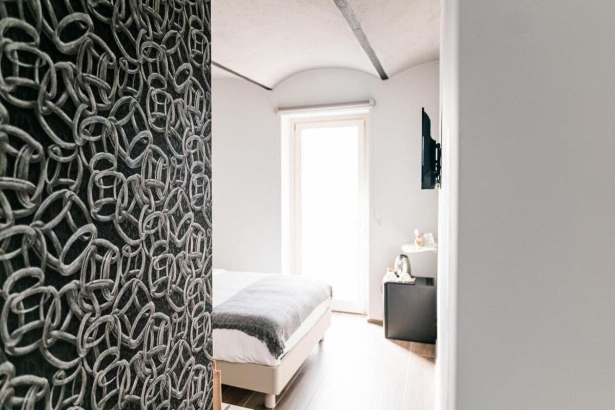 Une chambre à coucher avec un lit, une table de chevet et une armoire.