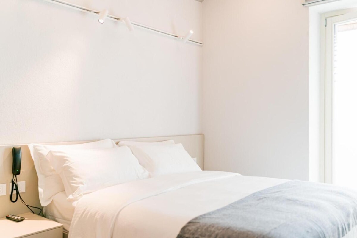 Ein Hotelzimmer mit Bett, Nachttisch und Telefon.