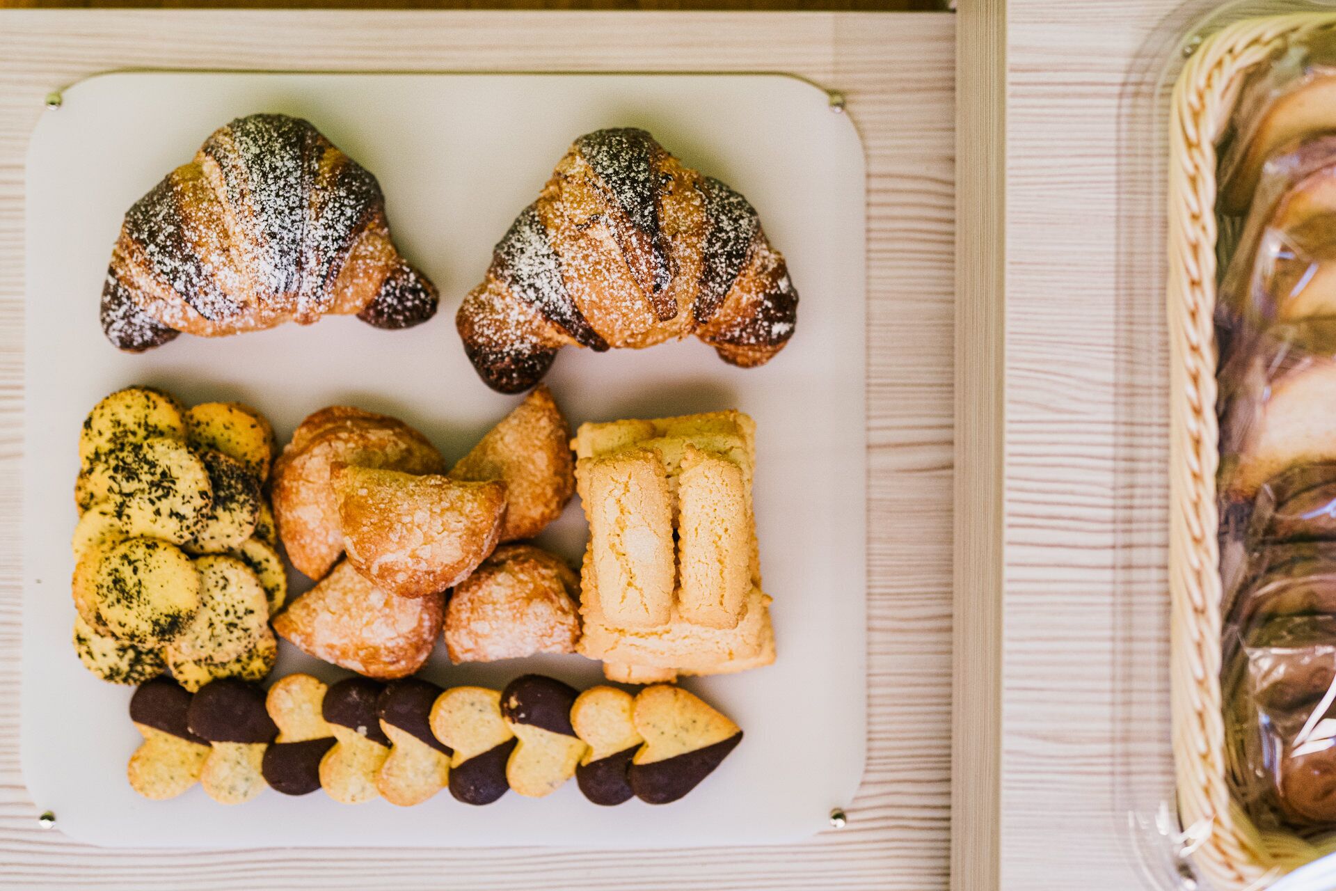 A tray of assorted pastries including croissants and cookies on a white plate.