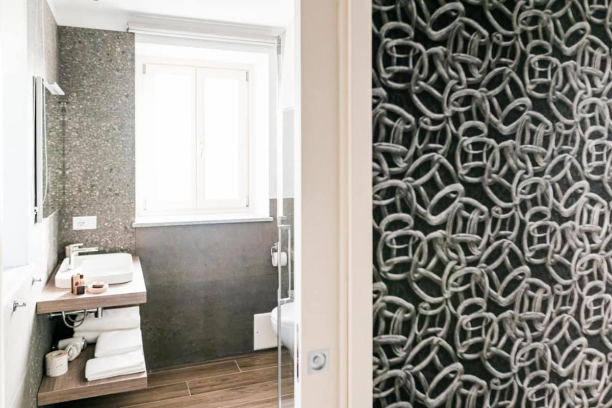 Une salle de bain avec un lavabo blanc, un miroir et une fenêtre.