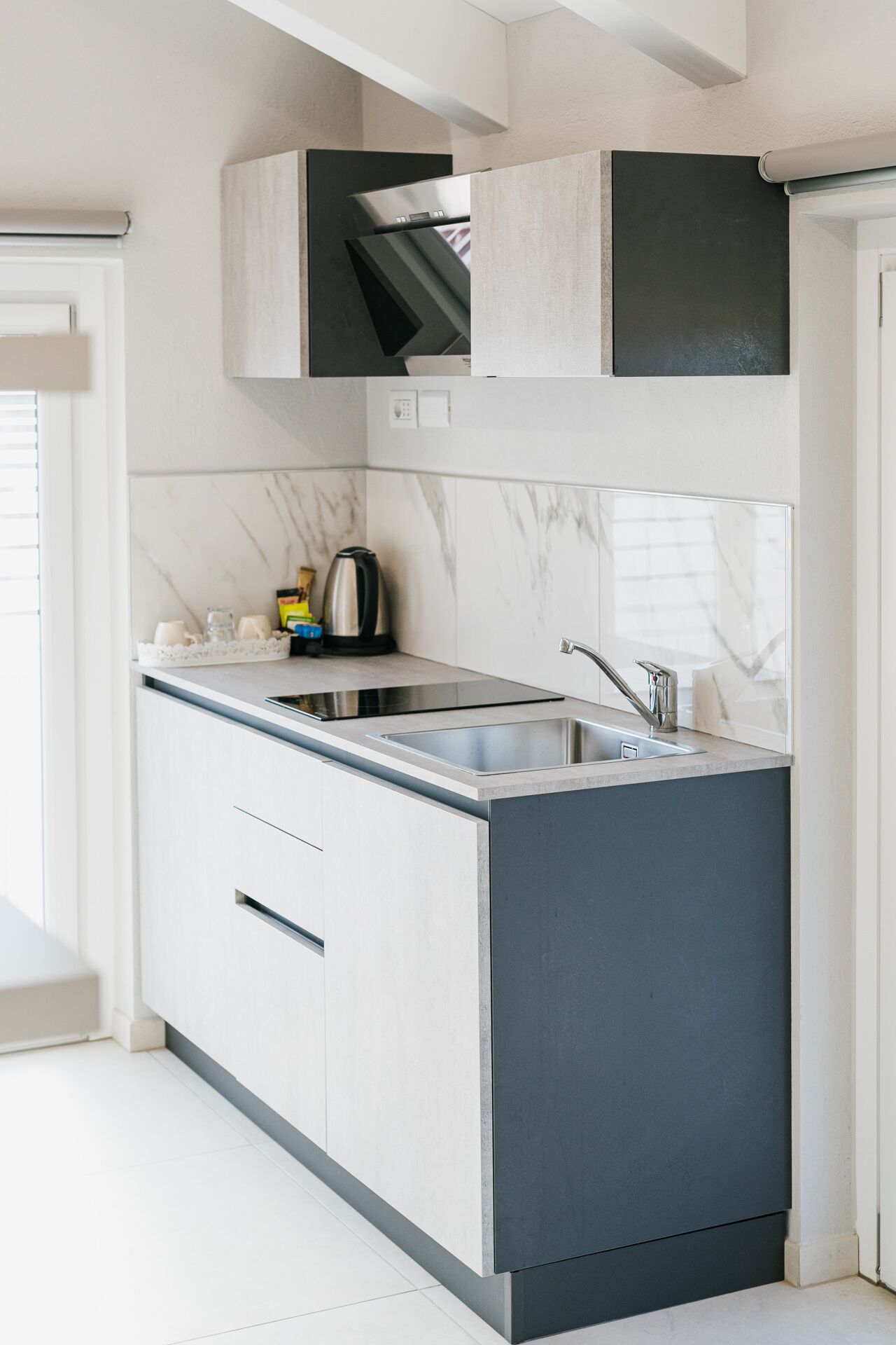 A modern kitchen with a built-in stove, a sink, and a coffee maker.