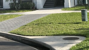 A modern building with a white facade, a number '4024' sign above the entrance, a staircase leading to an upper level, and a small landscaped area with grass and a palm tree. - Your Home in Orlando (Orlando)