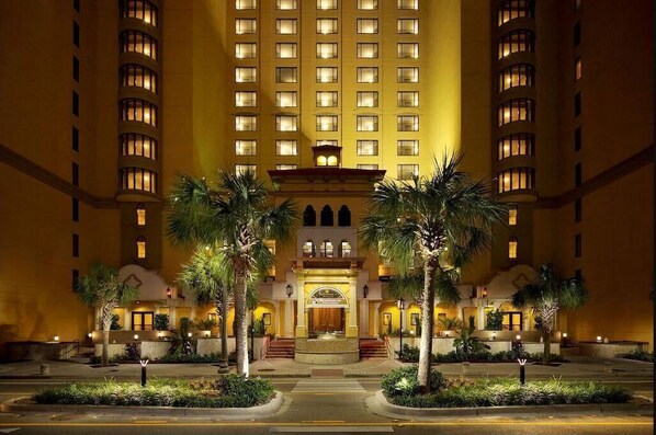 Stunning hotel with a central entrance and two wings, featuring balconies and windows.