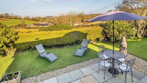 Un patio con mobiliario exterior, una mesa y una silla.