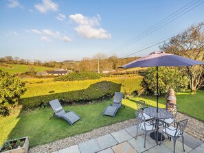 A patio with outdoor furniture, a table, and a chair. - 1 bedroom accommodation in Little Polgooth, near Saint Austell (Little Polgooth, near Saint Austell)