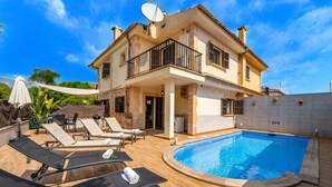 A two-story house with a swimming pool, lounge chairs, and a patio area. - House with pool Casa Jordi in Playa de Muro (Can Picafort)