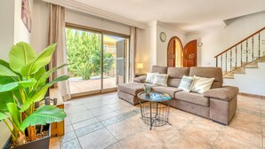 A living room with a sofa, a coffee table, and a potted plant. - House with pool Casa Jordi in Playa de Muro (Can Picafort)