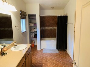 Un bagno con lavandino, specchio e vasca.