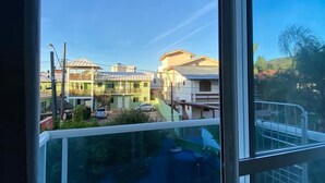 A balcony with a clear view of a residential area, including houses and a street. - GH Barra da Lagoa (Florianópolis)