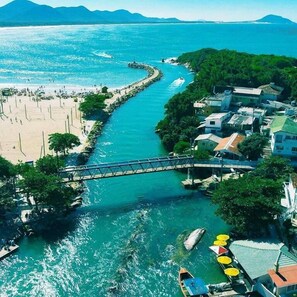 A coastal town with a beach, a river, and a bridge connecting the two. - GH Barra da Lagoa (Florianópolis)