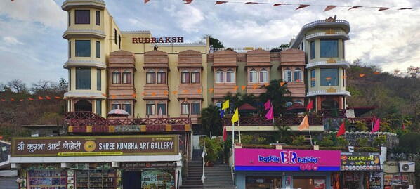 A multi-story building with a sign reading 'RUDRAKSH' and a shop named 'SHREE KUMBHA ART GALLERY' at the ground level.