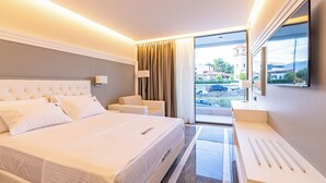 Habitación de hotel moderna con una cama grande, un escritorio y vistas al exterior.