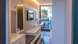 Un baño moderno con un espejo grande, un lavabo y un banco.
