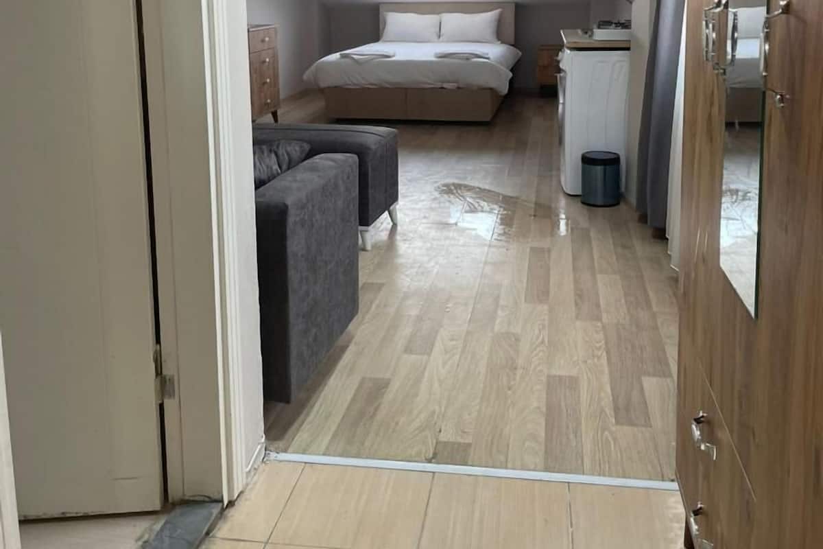A bedroom with a bed, a sofa, and a small kitchenette.