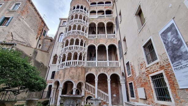 Un bâtiment historique doté de nombreux balcons et d’une fontaine dans la cour.