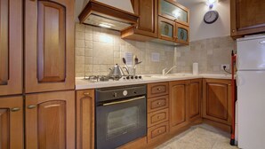 Une cuisine avec des meubles de rangement en bois, une cuisinière, un four et un réfrigérateur.