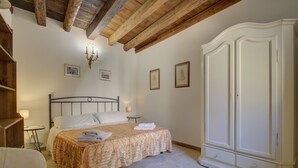 Une chambre à coucher avec un grand lit, une armoire et un lustre.