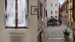 Une cour étroite donnant sur une chambre, avec un radiateur, une fenêtre ornée de rideaux légers et un tableau encadré accroché au mur.