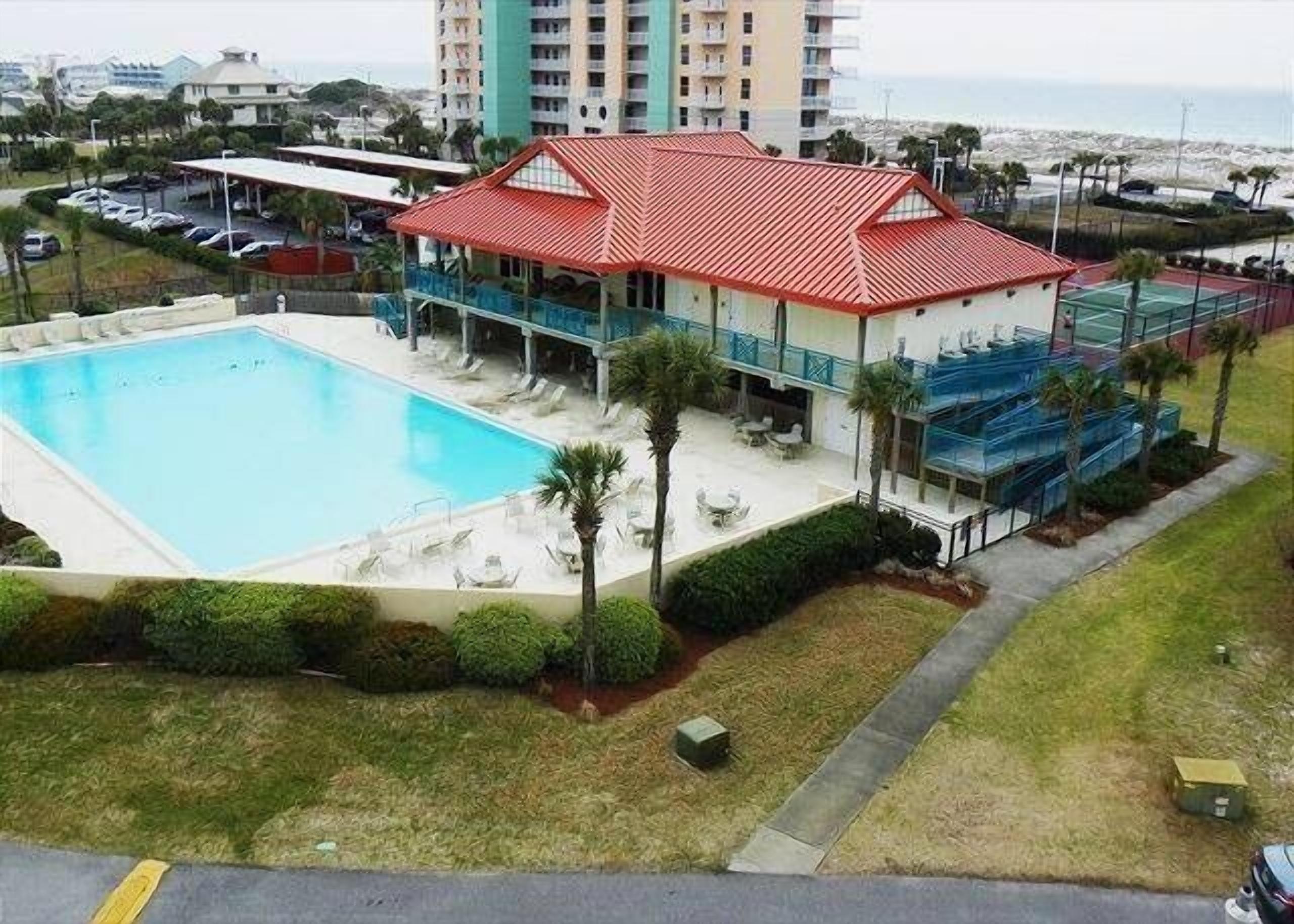 A hotel with a swimming pool, outdoor seating, and a view of the ocean.
