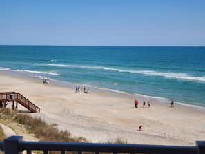 A beach with a wooden walkway leading to the water, a sandy shore, and people enjoying the beach. - Arrr Place. Beachfront, 1 BR, pool & beach access. 2 Queens, 2 bunks (North Topsail Beach)