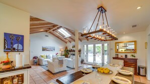 A spacious living area with a dining table set for a meal, a cozy seating area with a fireplace, and a kitchen with modern appliances. - Santa Barbara Vacation Rental w/ Pool & Hot Tub! (Santa Barbara)