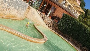 A swimming pool with a stone wall and a wooden deck. - Old ceramic factory close to Unesco itineraries (Sorano)