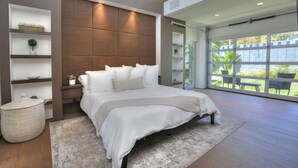 Une chambre moderne avec un grand lit, des étagères intégrées et une vue sur un patio.