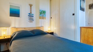A bedroom with a bed, nightstands, a wardrobe, and wall art. - Les Terrasses de l'Atlantique by Interhome (Lacanau)