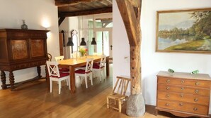 A dining area with a wooden table and chairs, a wooden cabinet, and a dresser with drawers. - Reethuus by Interhome (Sandbostel)