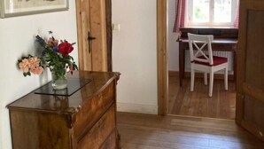 A room with wooden beams, a desk with a chair, a wooden dresser, and a painting on the wall. - Reethuus by Interhome (Sandbostel)