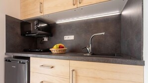 Una cucina moderna con mobili in legno, una cappa in acciaio inossidabile, un lavello incassato e una lavastoviglie.