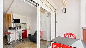 A modern kitchen with a microwave, sink, and red chairs. - WELCS ESTUDIO 070 EMP frente al Mar (Empuriabrava)