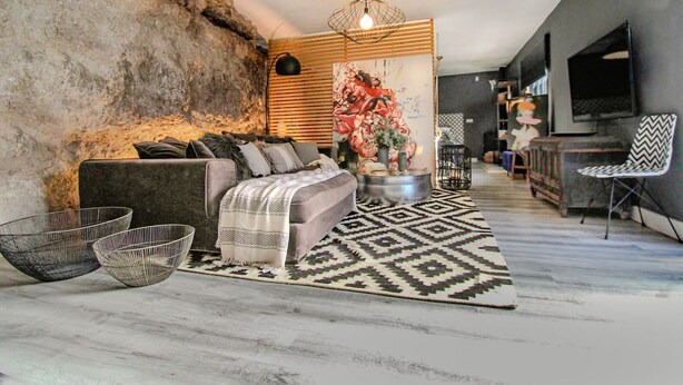 Un salon moderne avec un canapé, une table basse et un tapis à motifs.
