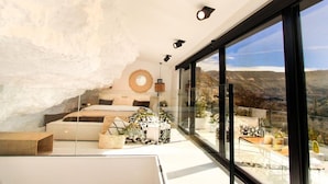 Un dormitorio moderno con un ventanal grande, una cama y vistas al exterior.