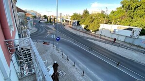 En stadsgata med en rondell, en gångbana för fotgängare och en byggnad med en balkong.