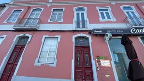 A pink building with a sign for 'Bonnelli' and 'CANTELARIA'. - Canto Doce Portela - C (Setúbal)