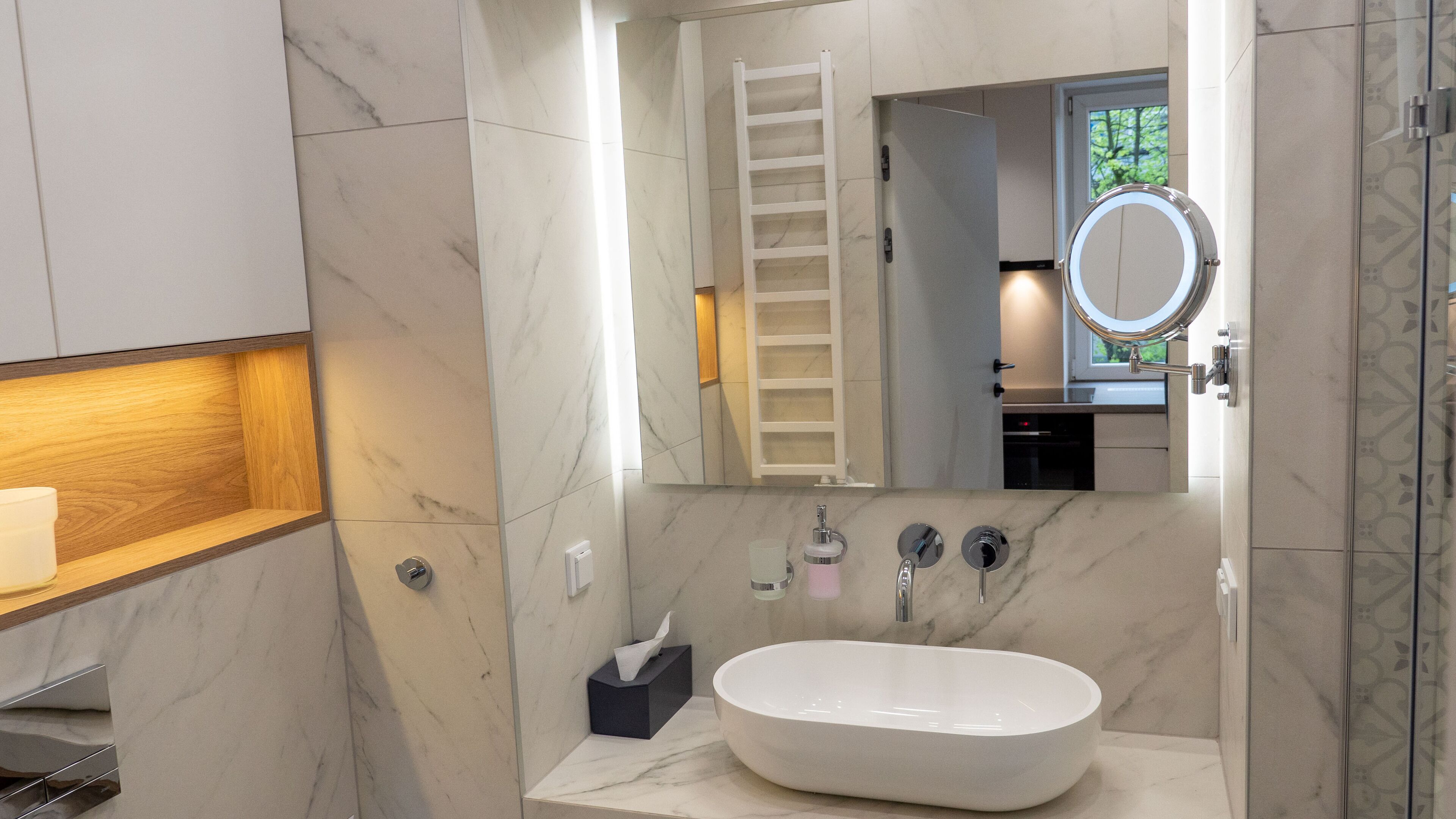 Une salle de bain moderne avec une baignoire sur pieds, un meuble-lavabo avec un miroir et un porte-serviettes.