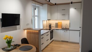 Uma cozinha moderna com lava-louças embutida, máquina de café e tábua de corte de madeira.