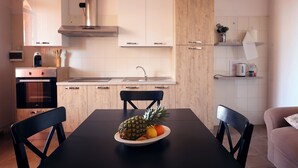 Una cocina moderna con armarios de madera, una campana extractora de acero inoxidable y una mesa de comedor con sillas.