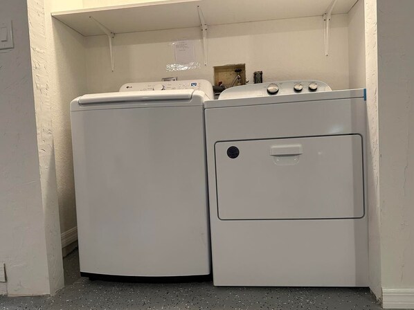 A laundry area with a washer and dryer, a small window, and a door leading to another room. - King Bed Cozy Home, Short Drive to WEC and Golden Ocala (Ocala)
