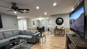 A modern living room with a sectional sofa, a coffee table, and a TV. - King Bed, Clean & Cozy, 10 Min to WEC Ocala (Ocala)
