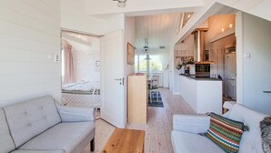 Una sala de estar moderna con un sofá, una mesa de centro y vista al área de la cocina.