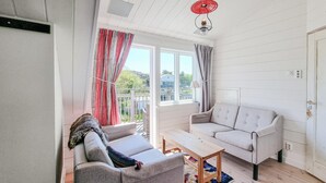 Una habitación acogedora con dos sofás, una mesa de centro de madera y vistas al exterior.