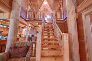 Eine Holztreppe führt zu einer erhöhten Galerie mit Blick auf die Küche darunter.