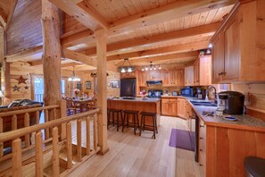 Ein Holzblock-Interieur mit Küchenzeile, Essbereich und einer Bar.